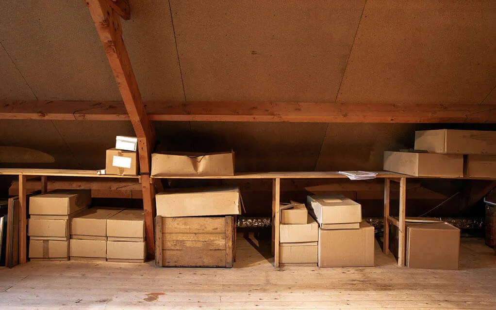 A number of unmarked boxes lay on the floor and on shelves built inside the attic of a home