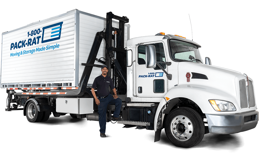A 1-800-PACK-RAT mini-mover driver stands on his truck smiling, as a mini-mover sits behind him with a portable storage container on the back