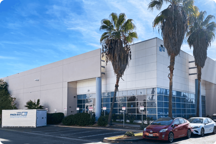 A 1-800-PACK-RAT portable storage container sits outside of the LA storage warehouse facility on a sunny day