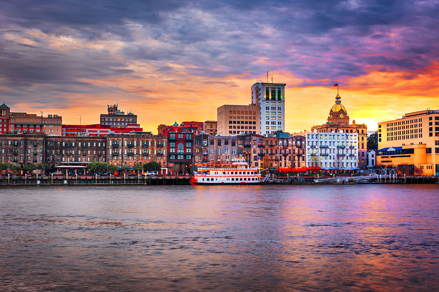 A view of River Street from the Savannah River with the Savannah City Hall gilded dome in the background at dusk on a mostly clear night
