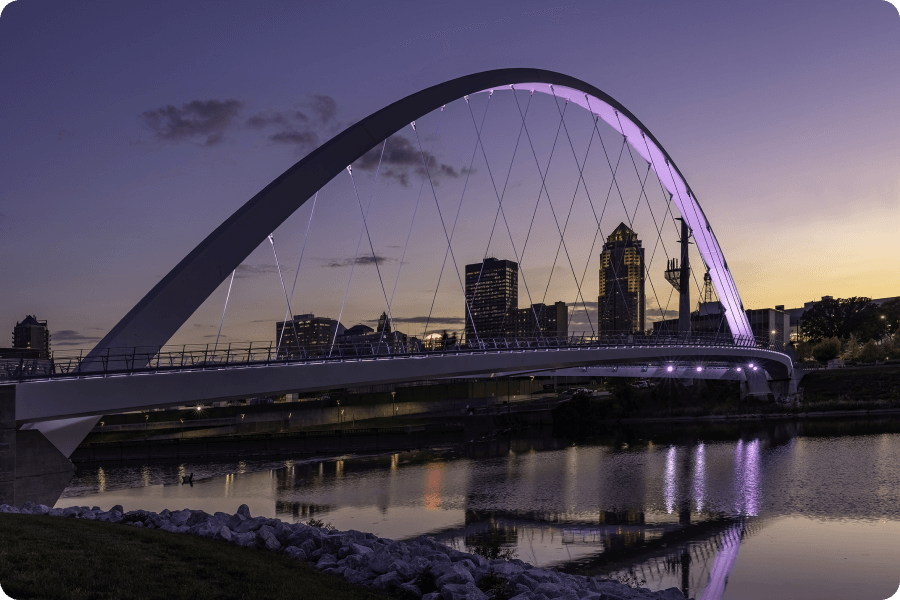A view of the George Washington Carver Bridge over the Raccoon River in Des Moines, IA at dusk
