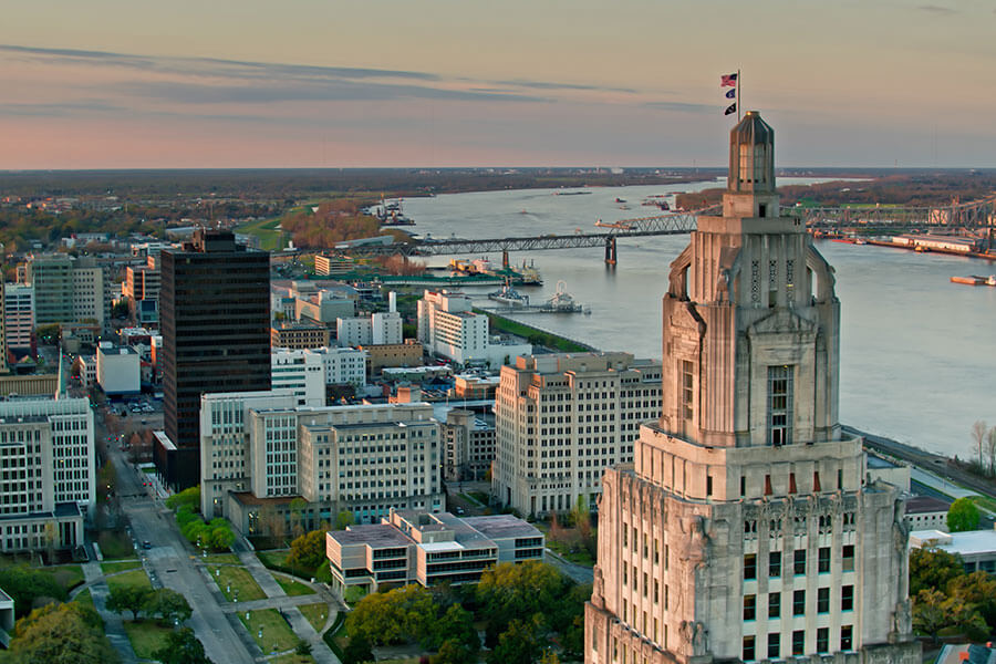 An aerial view at dusk of downtown Baton Rouge, LA and the State Capitol of Louisiana with the Mississippi River in the background