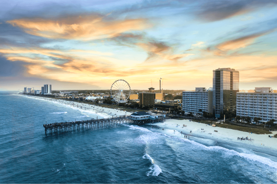 A aerial shot of the Myrtle Beach waterfront and pier from the oceanside at sunset
