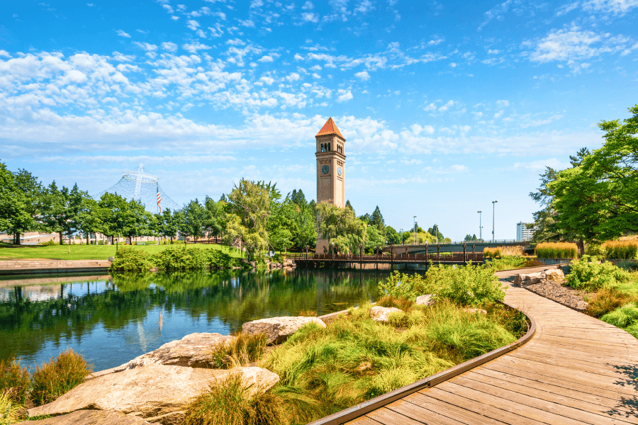 A beautiful sunny day view of the Clock Tower and Pavilion along the Spokane River Riverfront Park in Spokane, WA